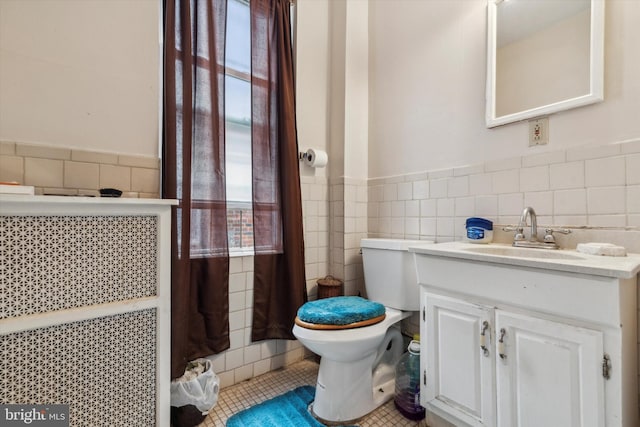 bathroom with walk in shower, vanity, tile walls, tile patterned flooring, and toilet