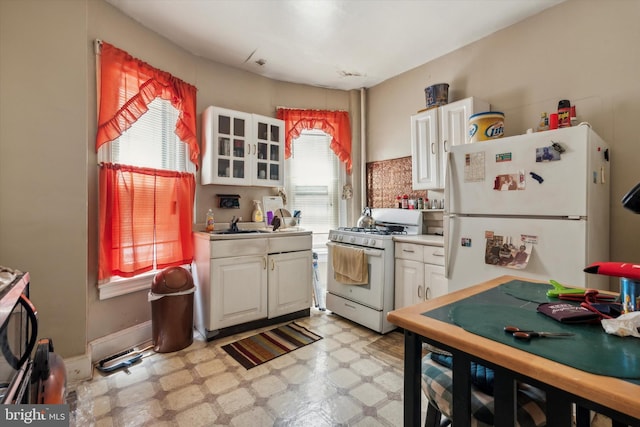 kitchen with white cabinets, white appliances, and sink