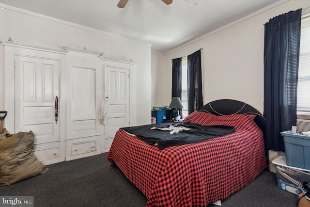 carpeted bedroom with ceiling fan, a closet, and crown molding