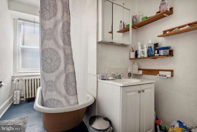 bathroom featuring vanity, a bathtub, and radiator