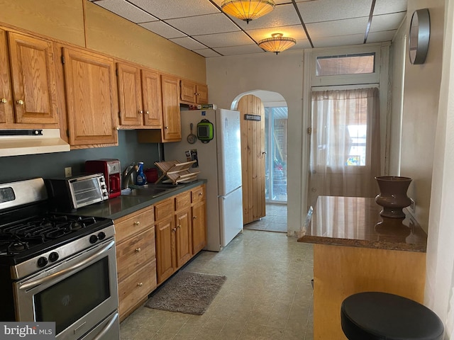 kitchen featuring white refrigerator, a paneled ceiling, sink, and gas stove