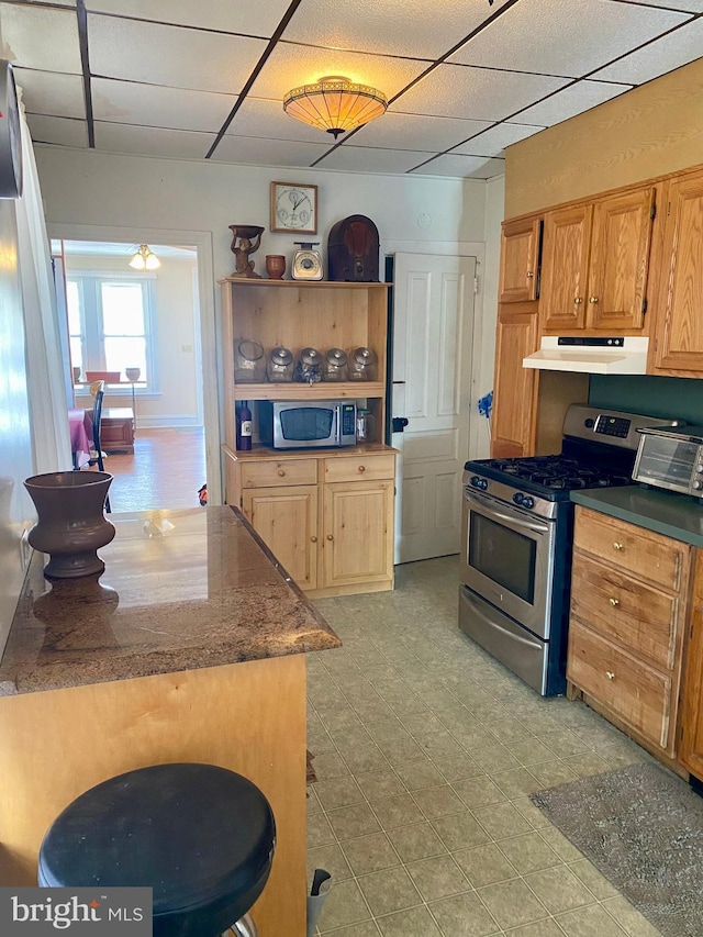 kitchen with appliances with stainless steel finishes, a drop ceiling, and ceiling fan