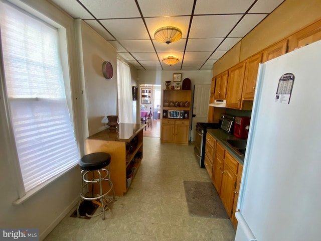 kitchen with white refrigerator and stainless steel gas range oven