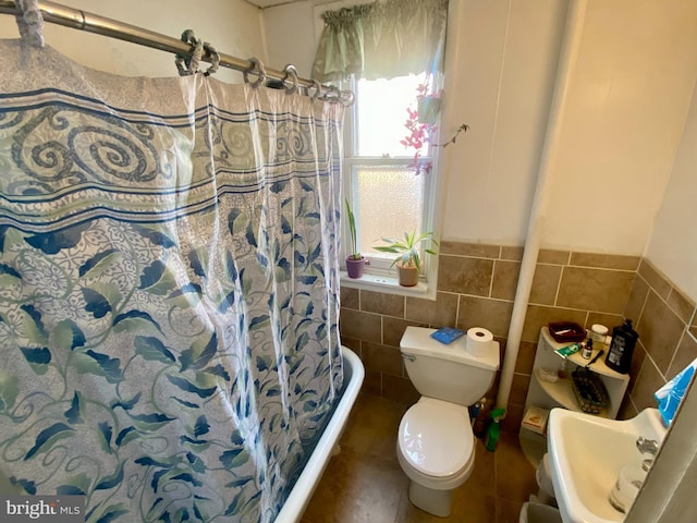 bathroom featuring tile walls, sink, toilet, and walk in shower