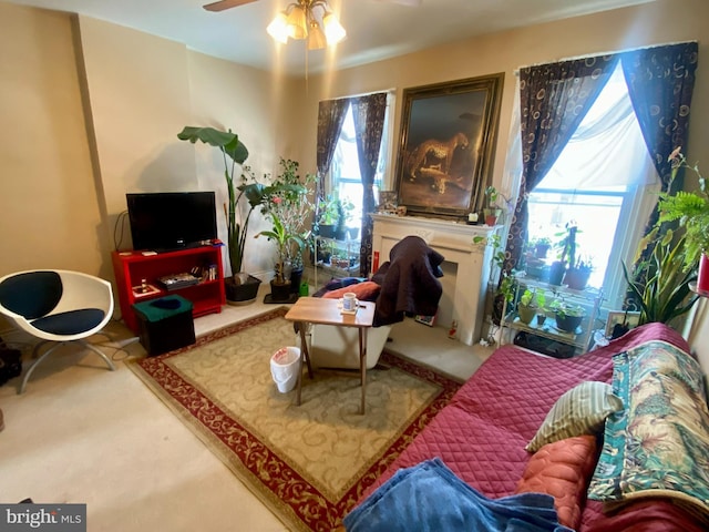 living area featuring carpet floors and ceiling fan