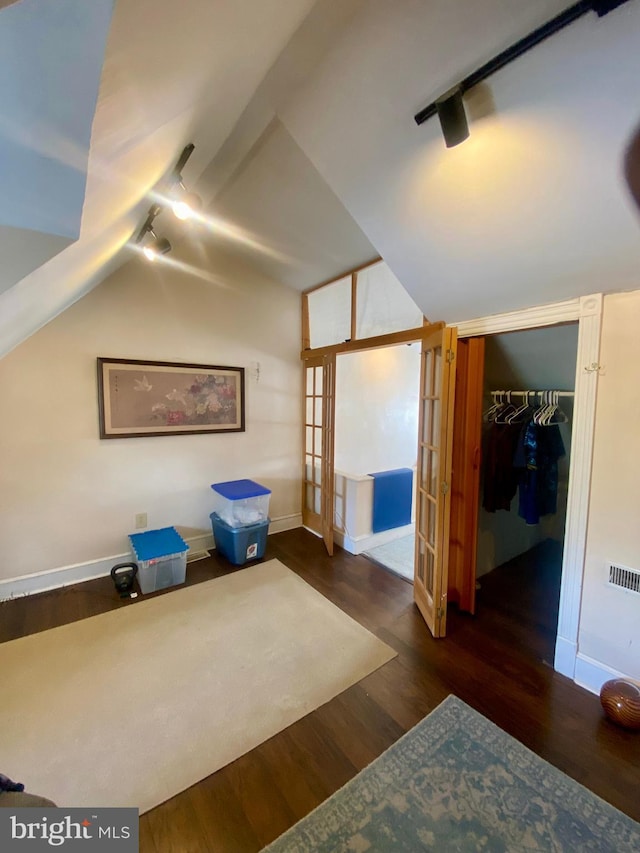 bonus room with dark hardwood / wood-style floors and vaulted ceiling