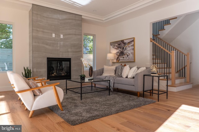 living room featuring a wealth of natural light, a large fireplace, and hardwood / wood-style flooring