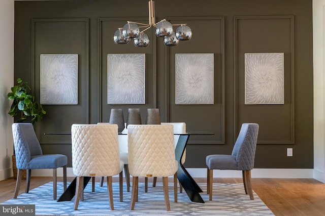 dining area with hardwood / wood-style floors and a chandelier