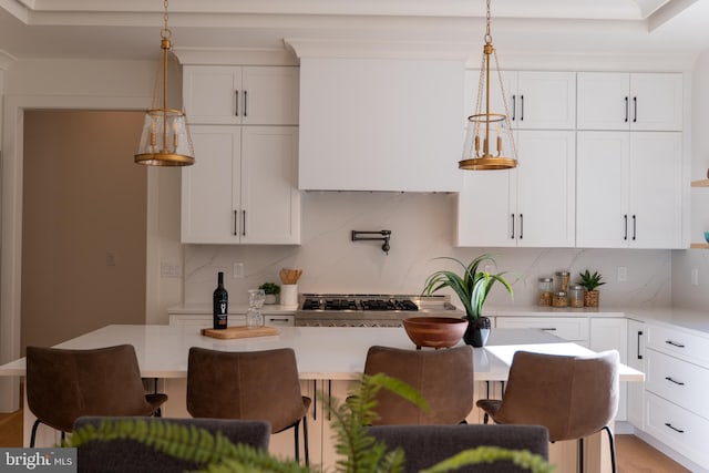 kitchen featuring white cabinets, tasteful backsplash, and hanging light fixtures