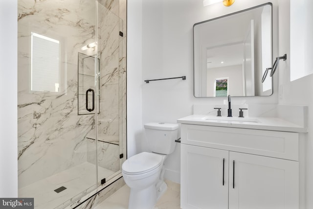 bathroom featuring vanity, a shower with shower door, and toilet