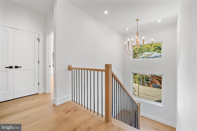 corridor featuring light hardwood / wood-style flooring and a chandelier