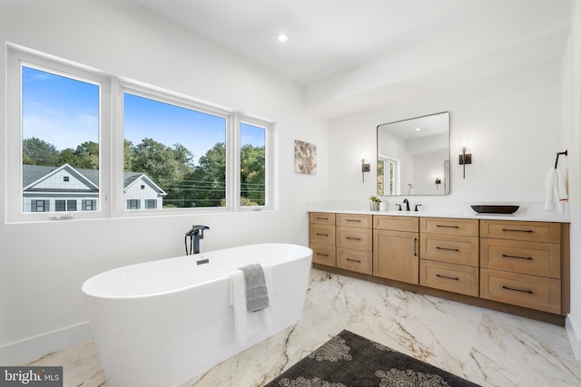 bathroom with a washtub and vanity