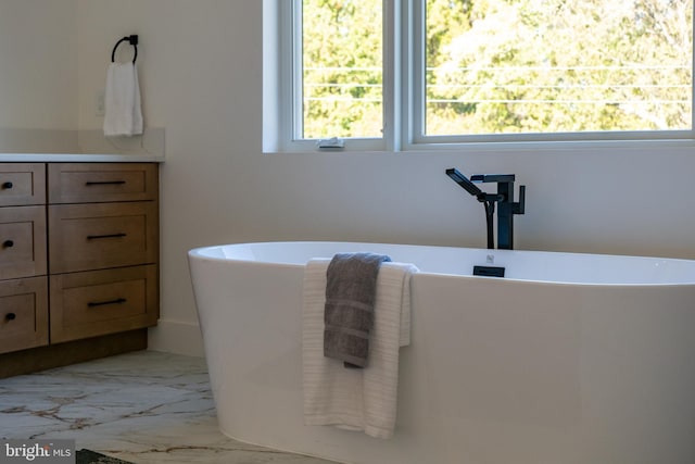 bathroom with vanity and a bath