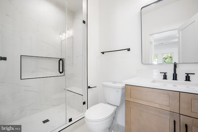 bathroom featuring vanity, toilet, and an enclosed shower