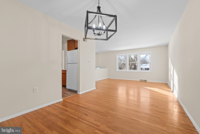 interior space with light hardwood / wood-style flooring and an inviting chandelier