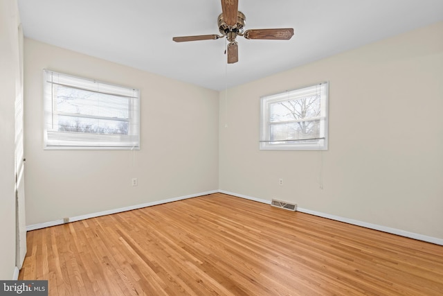 empty room with ceiling fan and light hardwood / wood-style flooring