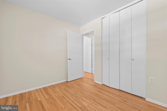 unfurnished bedroom featuring a closet and light hardwood / wood-style flooring