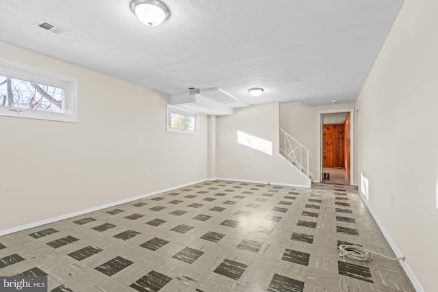 basement featuring a textured ceiling and a wealth of natural light