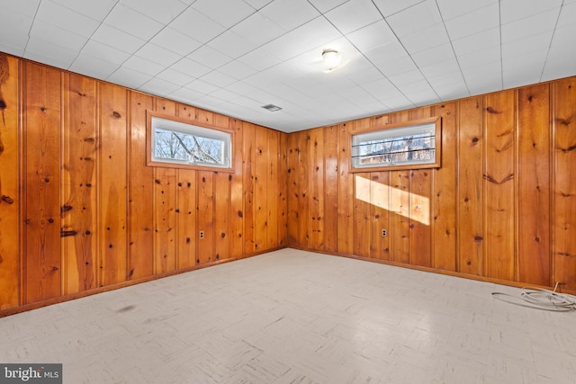 unfurnished room featuring wood walls