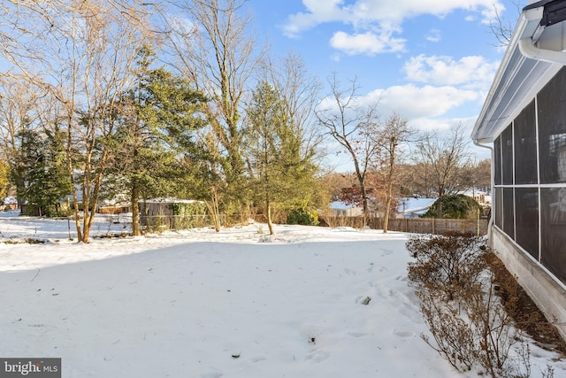 snowy yard with a sunroom