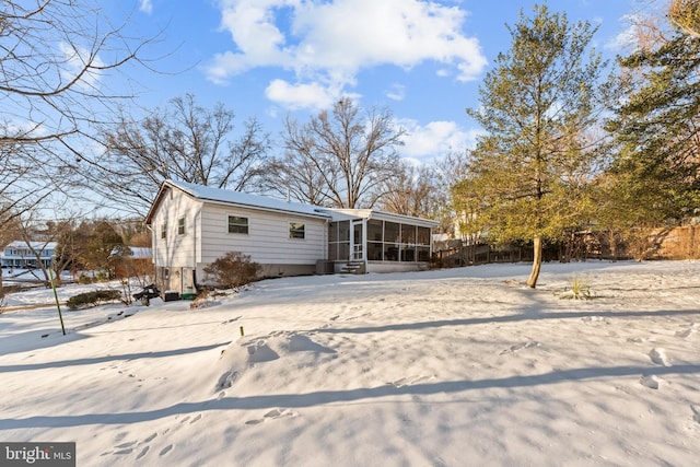 snow covered house with a sunroom