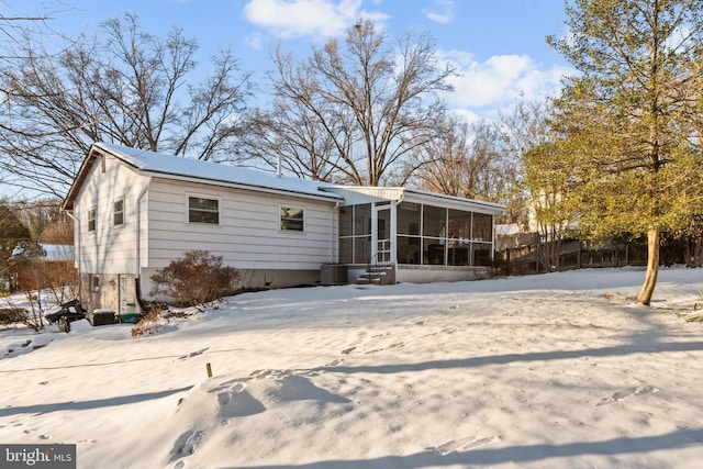 snow covered house with a sunroom