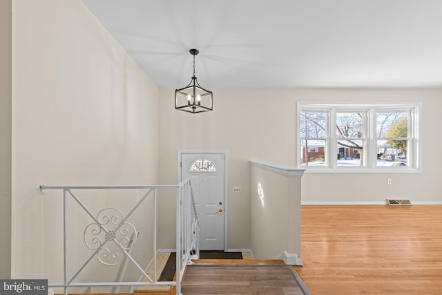 foyer entrance featuring a chandelier and hardwood / wood-style floors