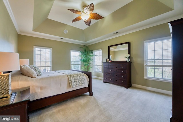 bedroom with ornamental molding, a tray ceiling, ceiling fan, and light colored carpet