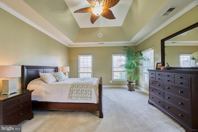 bedroom featuring ceiling fan, light colored carpet, ornamental molding, and a tray ceiling