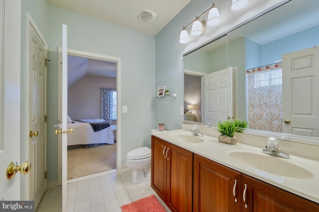 bathroom with tile patterned flooring, vanity, and toilet