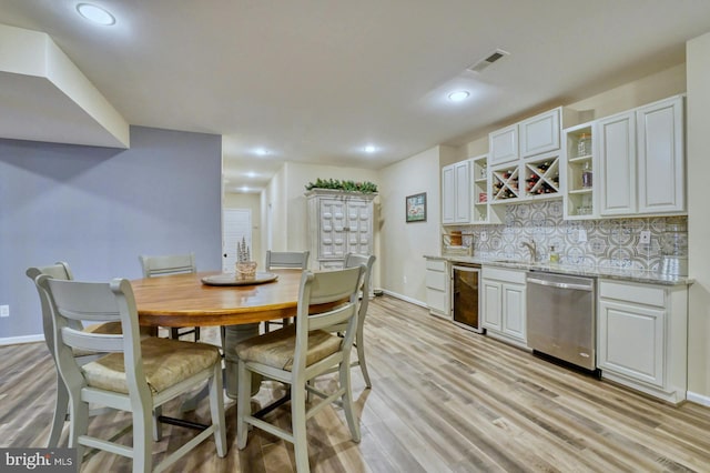 dining room featuring light hardwood / wood-style flooring and beverage cooler