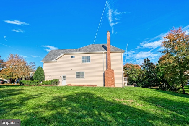 rear view of house featuring a lawn