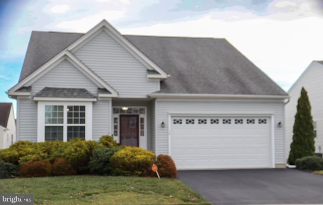 view of front of house featuring a garage and a front lawn