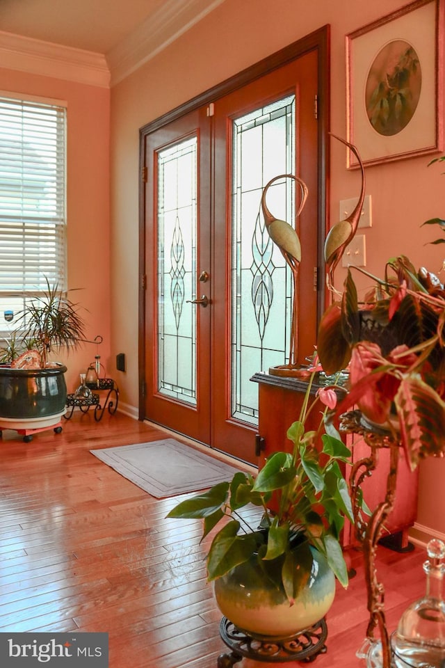 foyer entrance with french doors, hardwood / wood-style flooring, and crown molding