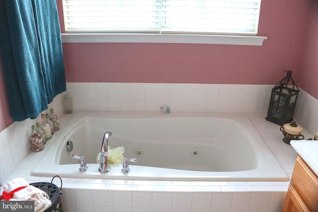 bathroom with tiled bath, a wealth of natural light, and vanity