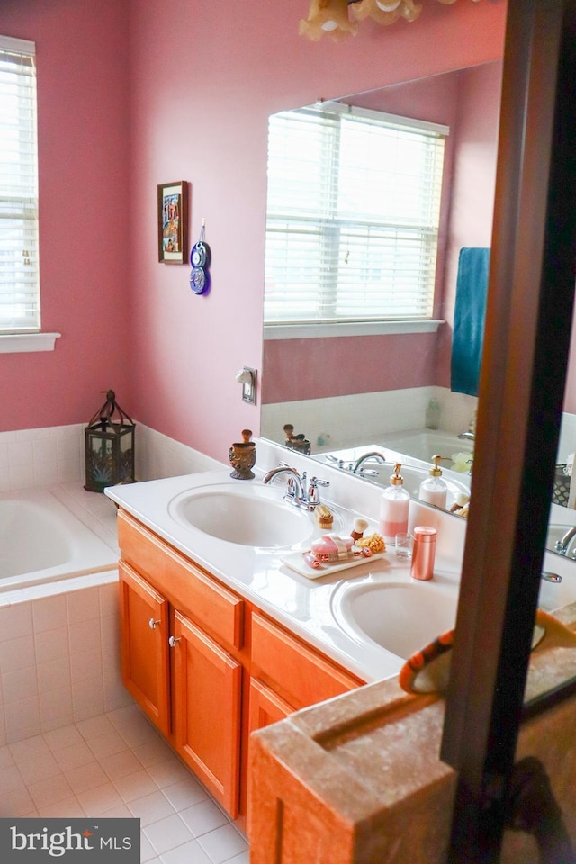 bathroom with tiled bath, tile patterned flooring, and vanity