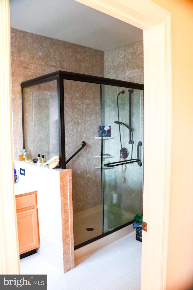 bathroom with tile patterned floors, vanity, and a shower with shower door