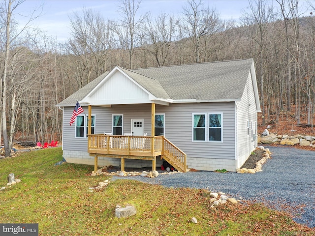 view of front of house with a deck and a front lawn