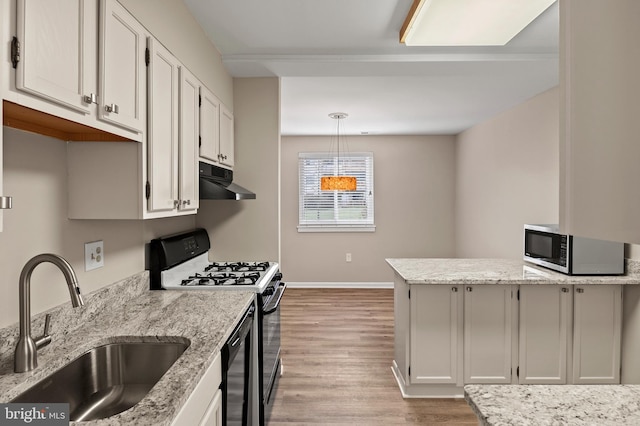 kitchen with white cabinetry, sink, hanging light fixtures, and appliances with stainless steel finishes