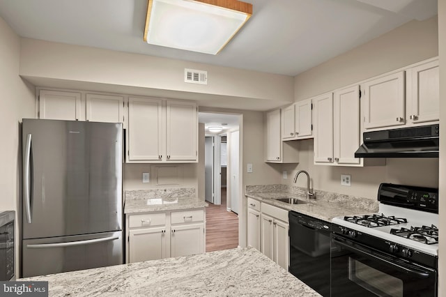 kitchen featuring stainless steel fridge, gas range gas stove, sink, dishwasher, and white cabinetry