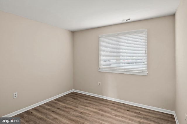 unfurnished room featuring dark hardwood / wood-style floors and a wealth of natural light