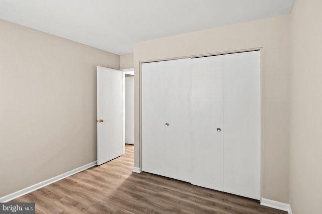 unfurnished bedroom with a closet and hardwood / wood-style floors