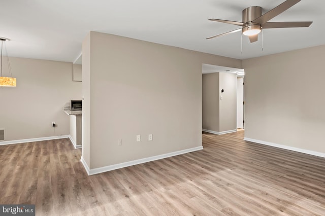 spare room with ceiling fan and light wood-type flooring