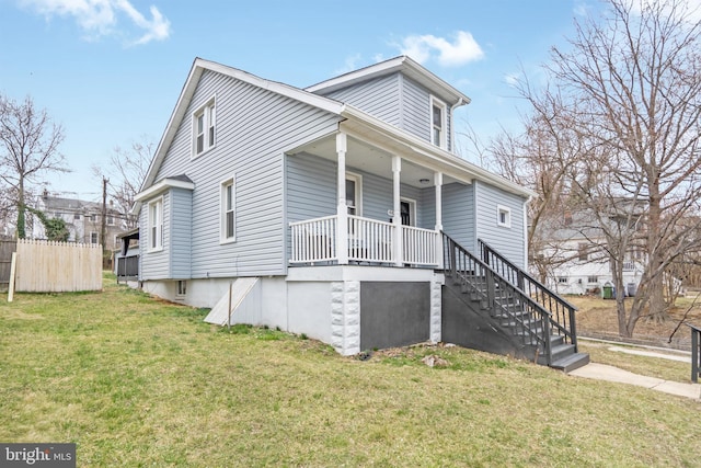 view of front of home featuring stairway, covered porch, a front lawn, and fence