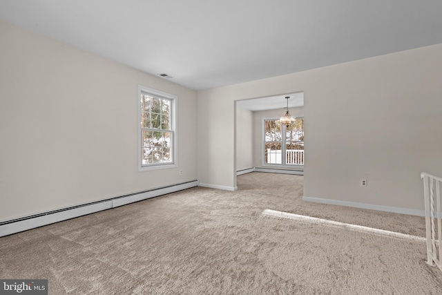 unfurnished room featuring light carpet, baseboard heating, and a chandelier