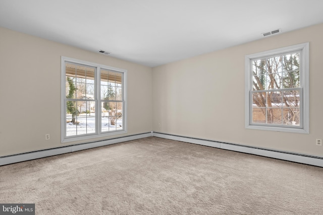 carpeted empty room featuring a healthy amount of sunlight and baseboard heating