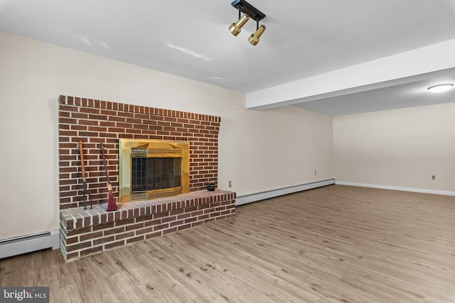 unfurnished living room featuring a baseboard radiator, light hardwood / wood-style flooring, beam ceiling, and a fireplace