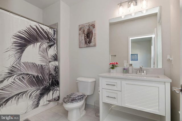 bathroom with toilet, vanity, and tile patterned floors