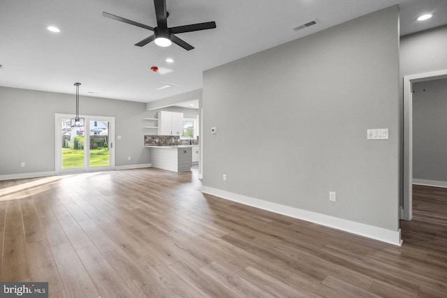 unfurnished living room with ceiling fan and light hardwood / wood-style flooring