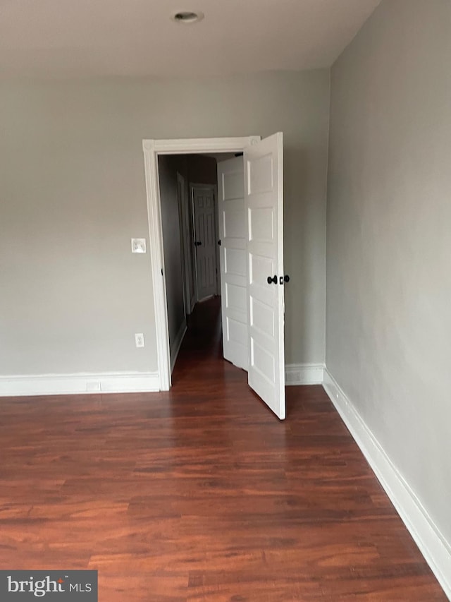 unfurnished bedroom with dark hardwood / wood-style flooring